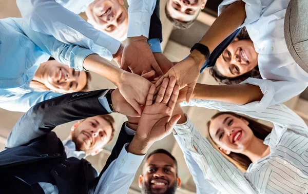 depositphotos_354950114-stock-photo-coworkers-standing-in-circle-holding