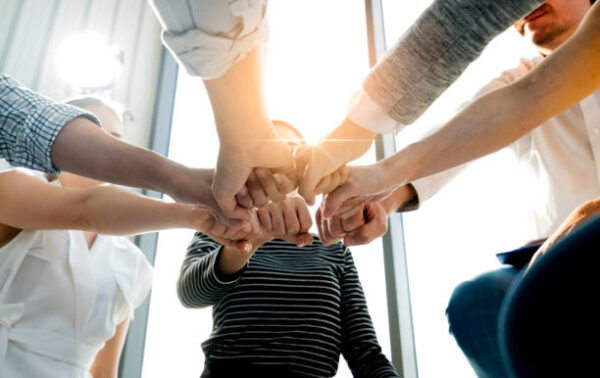 Close up top view of young and freshness energy business people putting their strong hands together. Stack of friendship hands. Unity and successful teamwork concept.